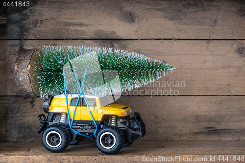 Image of christmas tree on a yellow toy car