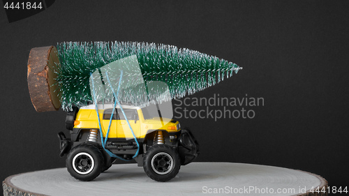 Image of christmas tree on a yellow toy car