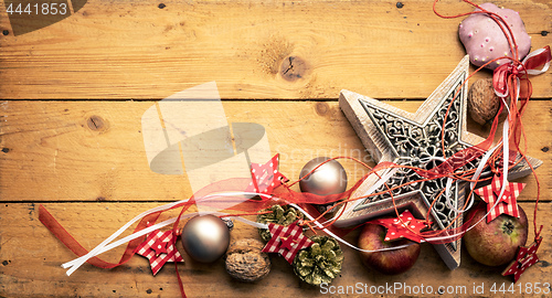 Image of Christmas decoration red ribbon on a star with wooden background