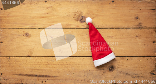 Image of red Santa Claus hat with wooden background