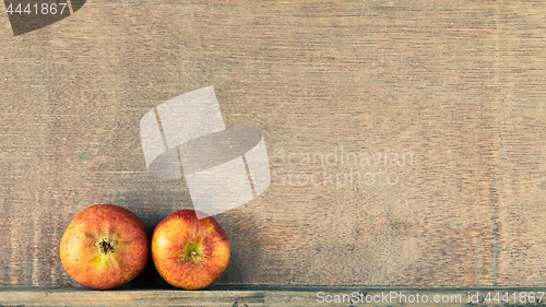 Image of wooden background with two small apples
