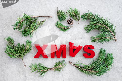 Image of Pine branches and the word Xmas written upside-down