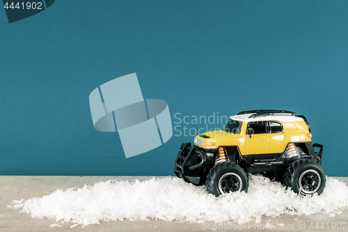 Image of yellow SUV monster car truck toy in winter snow