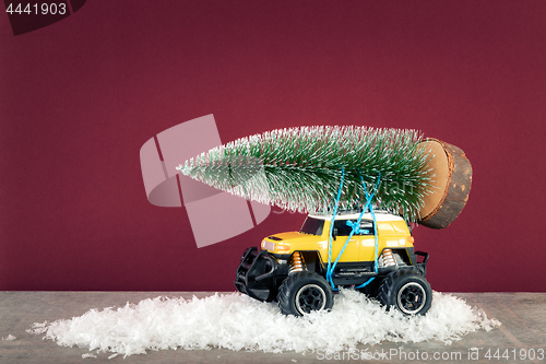 Image of yellow SUV monster car truck toy with fir tree