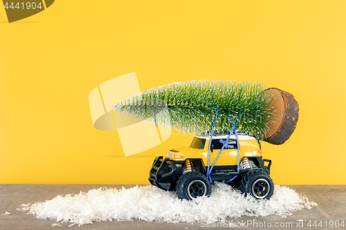 Image of yellow SUV monster car truck toy with fir tree