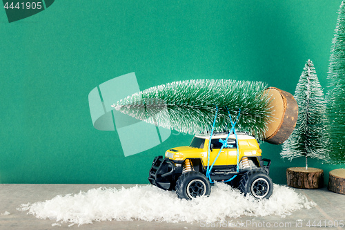 Image of yellow SUV monster car truck toy with fir tree