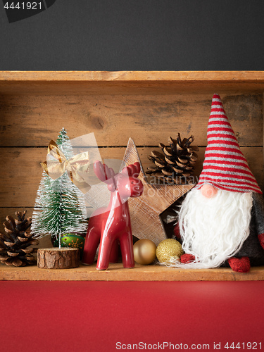 Image of Christmas decoration deer figure and gnome in a wooden box backg