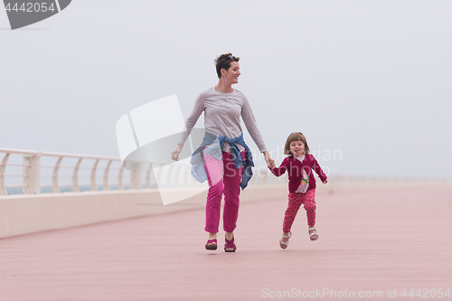 Image of mother and cute little girl on the promenade by the sea