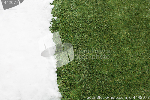 Image of Meeting snow on green grass close up - between winter and spring concept background