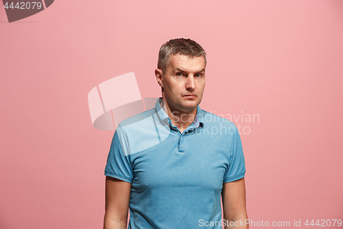 Image of Suspiciont. Doubtful pensive man with thoughtful expression making choice against pink background