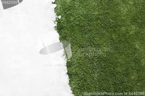 Image of Meeting snow on green grass close up - between winter and spring concept background