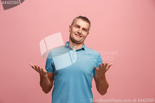 Image of The happy business man standing and smiling against pink background.