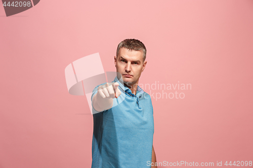 Image of The serious business man point you and want you, half length closeup portrait on pink background.