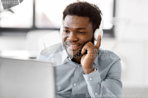 Image of businessman with headphones and computer at office