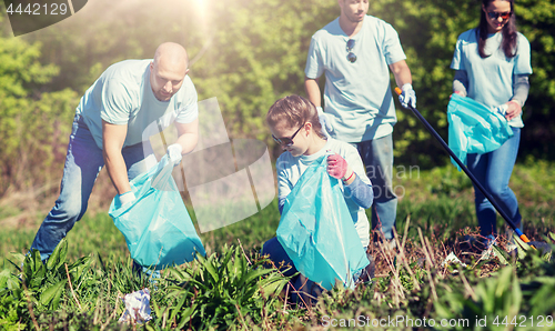 Image of volunteers with garbage bags cleaning park area