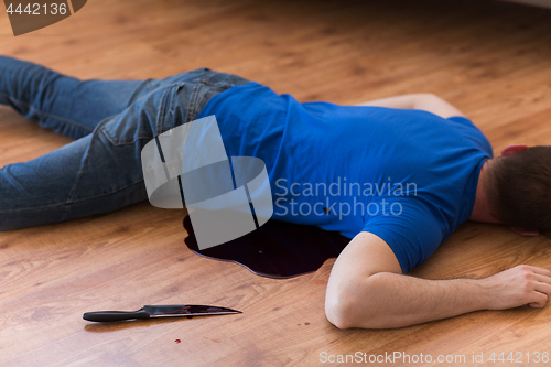 Image of dead man body lying on floor at crime scene