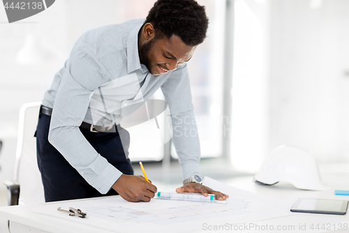 Image of african architect with blueprint at office