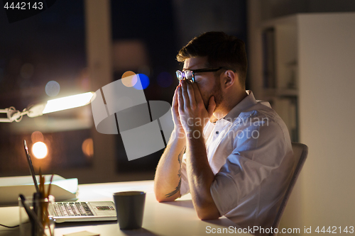 Image of tired businessman with laptop at night office