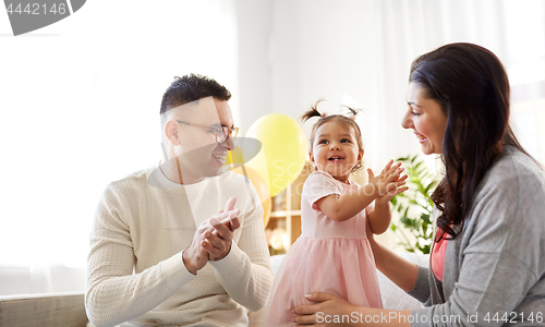 Image of happy baby girl and parents at home birthday party