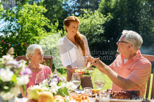 Image of happy family having dinner or summer garden party