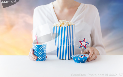 Image of woman eating popcorn with drink in glass mason jar