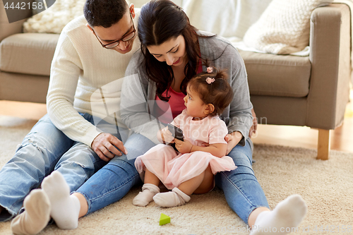 Image of little girl with smartphone and parents at home