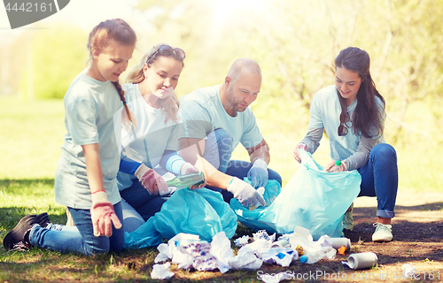 Image of volunteers with garbage bags cleaning park area