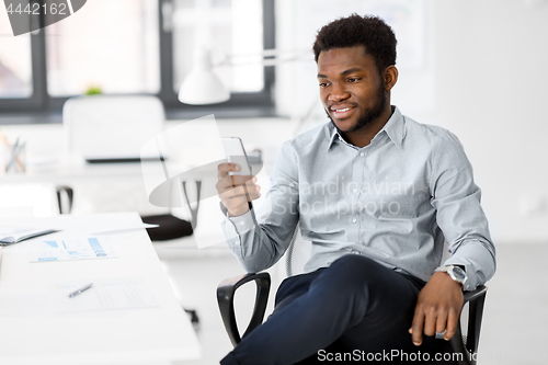 Image of businessman with smartphone at office