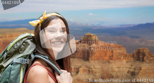 Image of happy woman with backpack over grand canyon