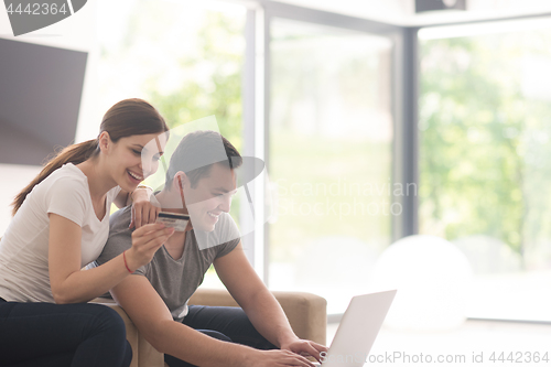 Image of happy young couple buying online