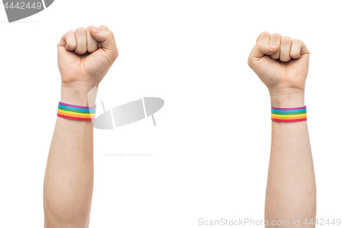 Image of hands with gay pride rainbow wristbands shows fist