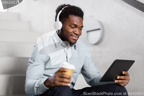 Image of businessman with headphones and tablet pc