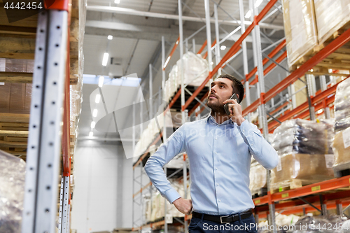 Image of businessman calling on smartphone at warehouse