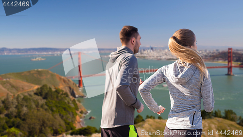 Image of happy couple running over golden gate bridge