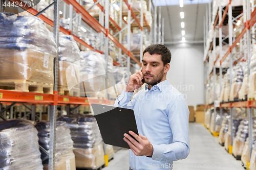 Image of businessman calling on smartphone at warehouse