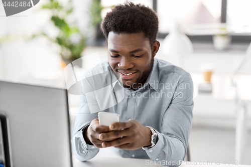 Image of businessman with smartphone at office