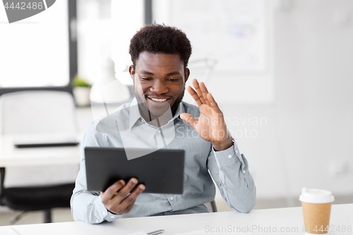 Image of businessman having video chat on tablet at office