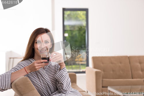 Image of young woman in a bathrobe enjoying morning coffee