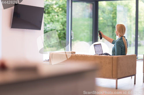 Image of Young woman using laptop at home