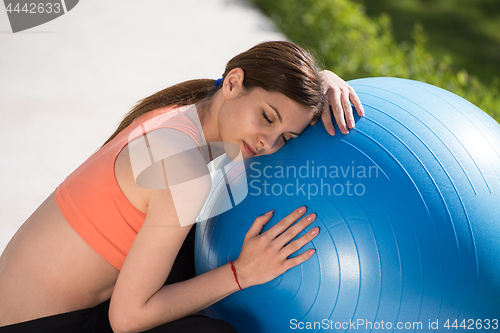 Image of woman doing exercise with pilates ball