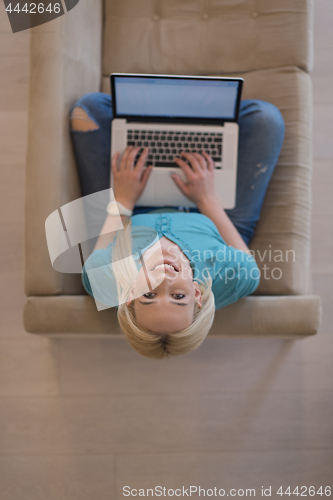 Image of Young woman using laptop at home top view