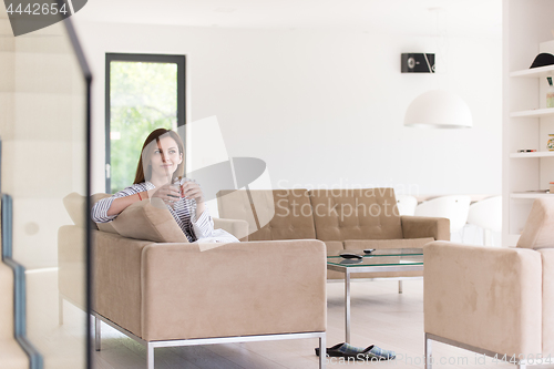 Image of young woman in a bathrobe enjoying morning coffee