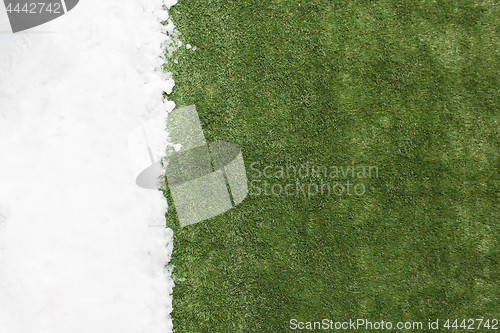 Image of Meeting snow on green grass close up - between winter and spring concept background