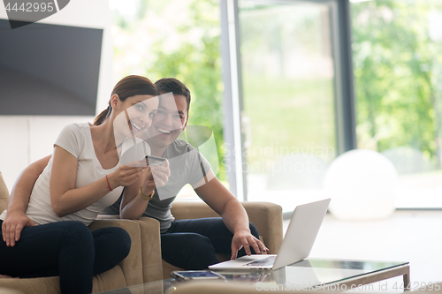 Image of happy young couple buying online