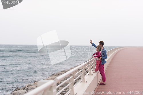 Image of mother and cute little girl on the promenade by the sea