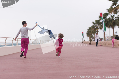 Image of mother and cute little girl on the promenade by the sea