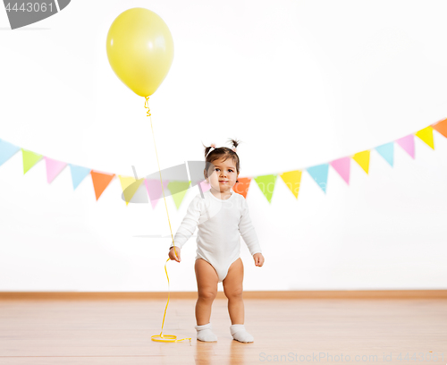 Image of baby girl with balloons on birthday party