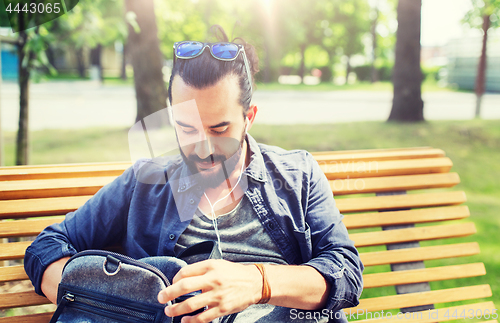 Image of man with backpack and earphones in city