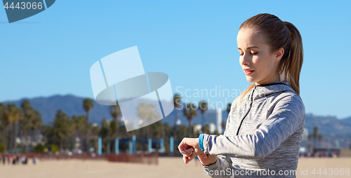Image of woman with fitness tracker training outdoors