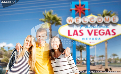 Image of happy friends over welcome to las vegas sign